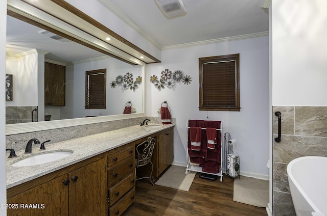 full bathroom featuring visible vents, wood finished floors, ornamental molding, and a sink