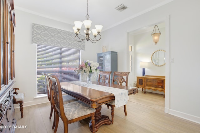 502 River Woods Dr, Lafayette, LA 70508 - dining area featuring a chandelier, light wood-style floors, ornamental molding, and baseboards