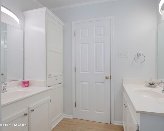 502 River Woods Dr, Lafayette, LA 70508 - bathroom with two vanities, wood finished floors, crown molding, and baseboards