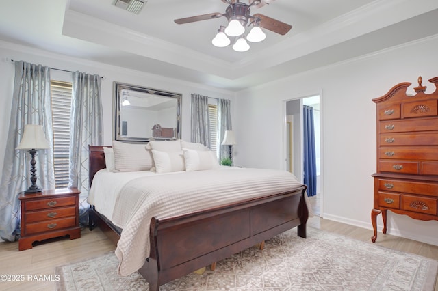 502 River Woods Dr, Lafayette, LA 70508 - bedroom with multiple windows, a raised ceiling, light wood-type flooring, ornamental molding, and ceiling fan