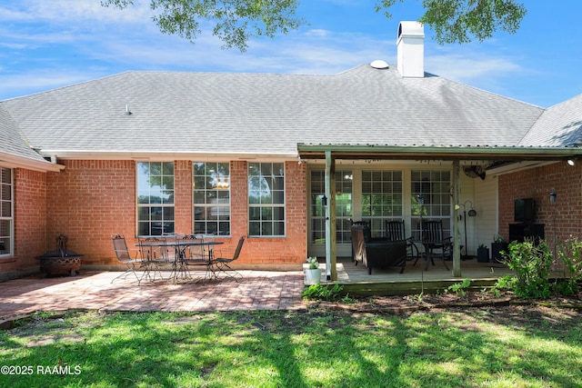 502 River Woods Dr, Lafayette, LA 70508 - back of property featuring a chimney, a lawn, a patio area, brick siding, and roof with shingles