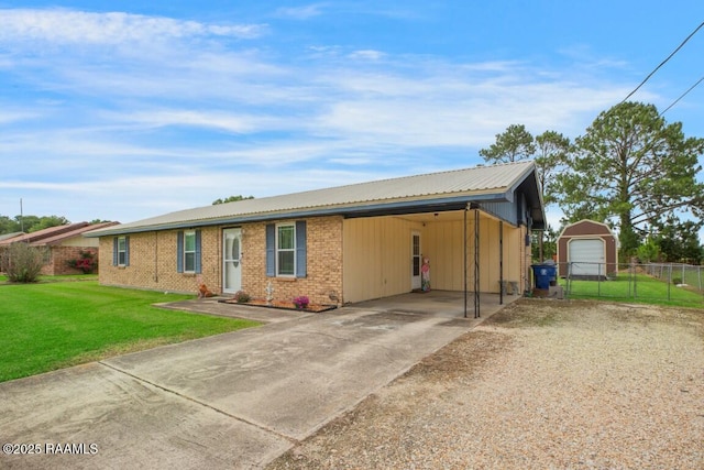 single story home with fence, a carport, a front lawn, an outbuilding, and driveway