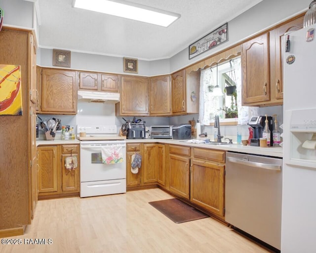 kitchen with white appliances, a sink, under cabinet range hood, and light wood-style floors