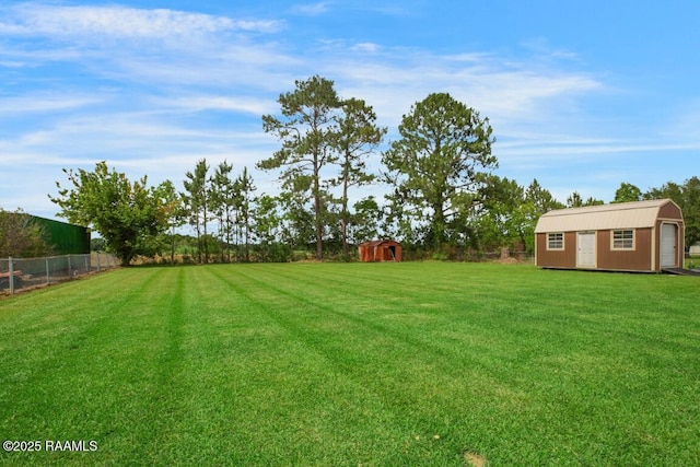 view of yard featuring an outbuilding, fence, and a storage unit