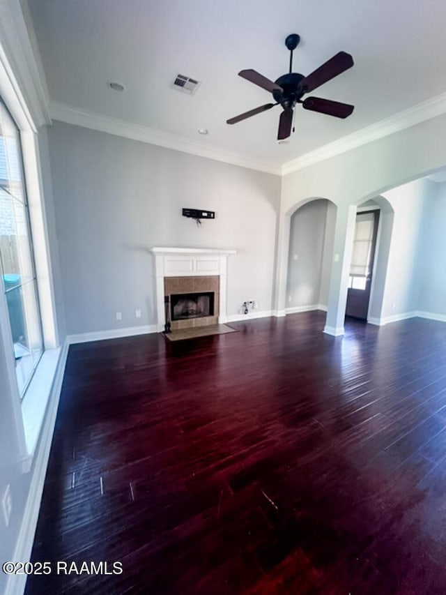 204 Red Cedar Ln, Youngsville, LA 70592 - unfurnished living room featuring ceiling fan, visible vents, arched walkways, wood finished floors, and a tile fireplace