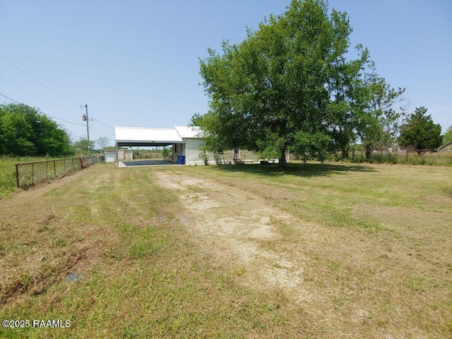 view of yard featuring fence, driveway, and a detached carport