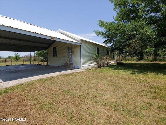 view of side of property with a yard, metal roof, entry steps, and an attached carport