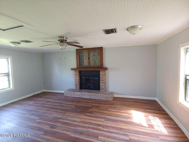 unfurnished living room featuring visible vents, crown molding, wood finished floors, baseboards, and ceiling fan