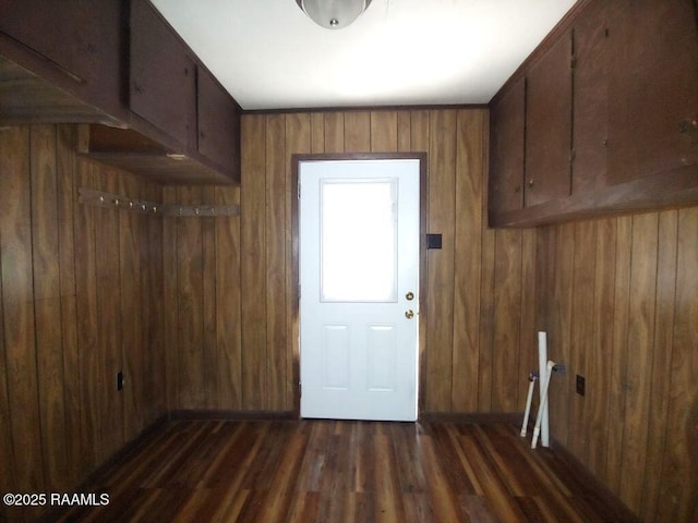 laundry room featuring wood walls and dark wood finished floors