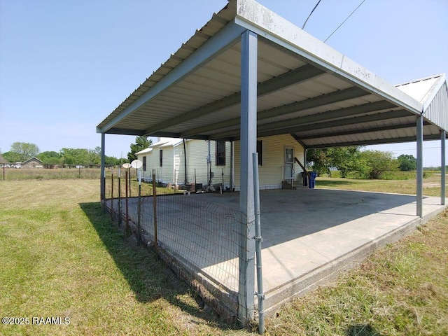 view of parking featuring fence and a carport