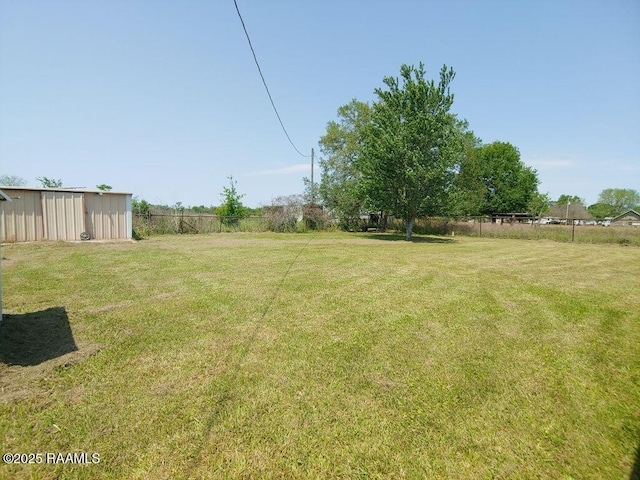 view of yard featuring fence and an outdoor structure