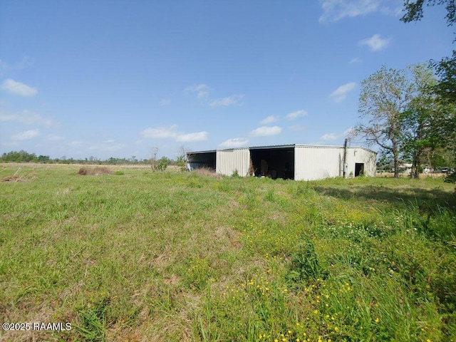 view of yard with a pole building and an outbuilding