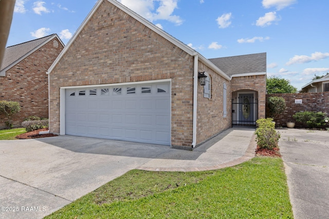 view of front of home featuring brick siding, a garage, roof with shingles, and driveway