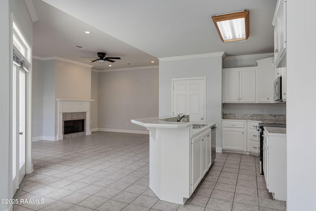 kitchen with a fireplace, open floor plan, recessed lighting, a sink, and appliances with stainless steel finishes