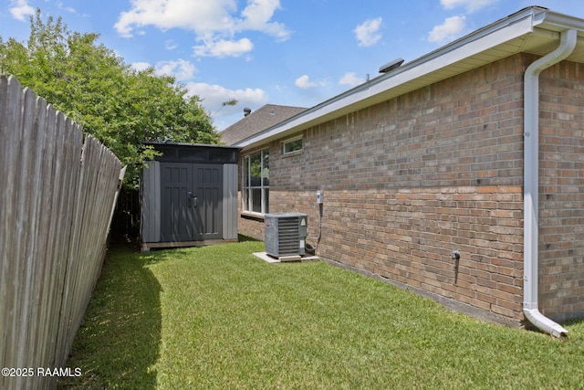 view of side of home with brick siding, cooling unit, a shed, and a fenced backyard