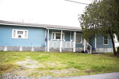 view of front of property featuring a front yard and covered porch
