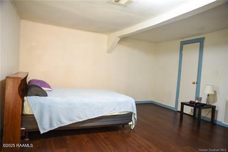 bedroom with baseboards, visible vents, and wood finished floors