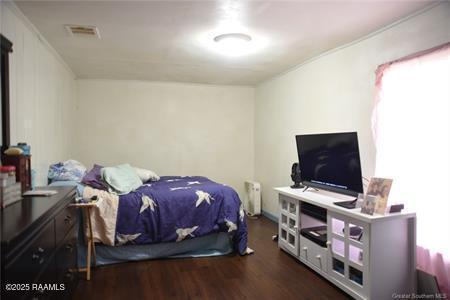 bedroom with visible vents and wood finished floors
