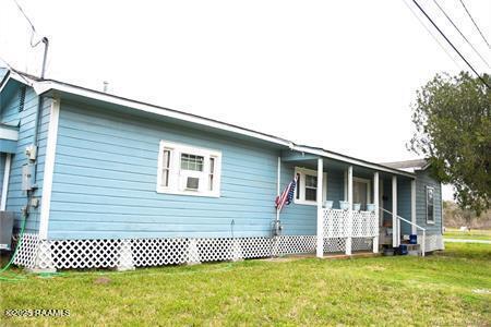 view of side of home featuring a yard and covered porch