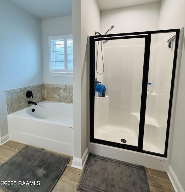131 Wild Cherry Ln, Lafayette, LA 70508 - bathroom featuring a shower stall, baseboards, wood finished floors, and a garden tub