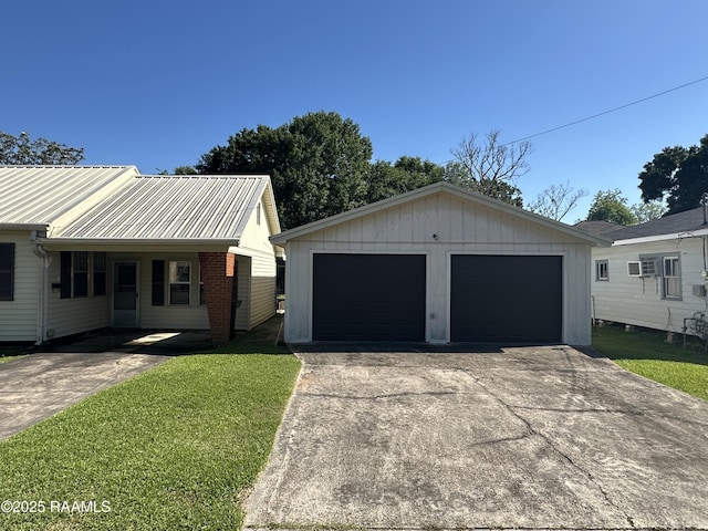 ranch-style home featuring an outbuilding, a front lawn, a wall mounted air conditioner, and a garage