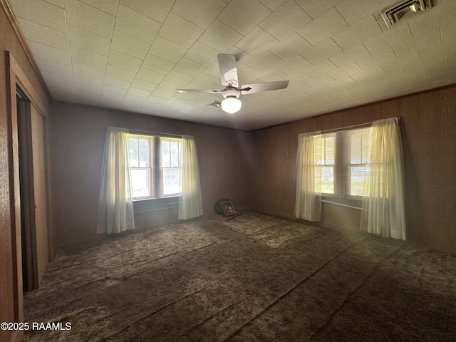 unfurnished room featuring ceiling fan, visible vents, a wealth of natural light, and carpet