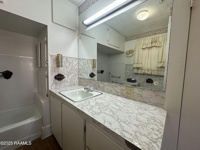 bathroom featuring vanity, tasteful backsplash, and brick floor