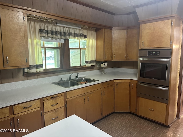 kitchen featuring light countertops, stainless steel oven, a sink, and a warming drawer