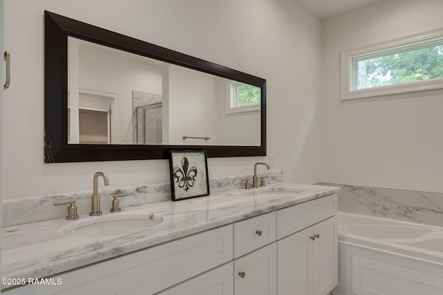 full bath featuring plenty of natural light, double vanity, a garden tub, and a stall shower