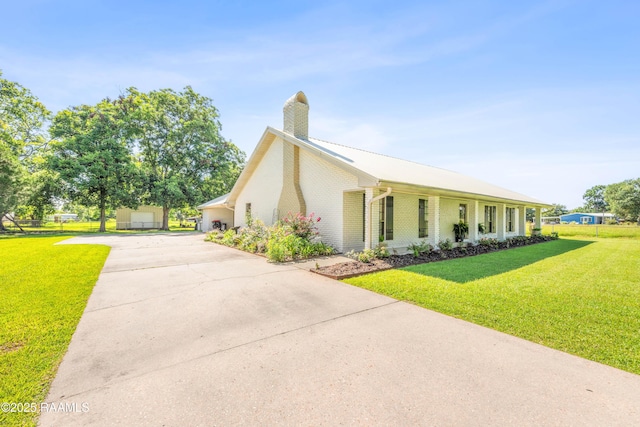 319 Roger Rd, Lafayette, LA 70507 - view of front of house with driveway, a chimney, brick siding, and a front lawn