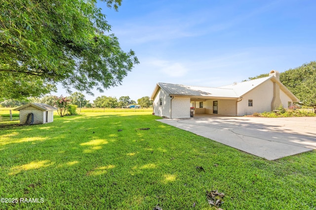 319 Roger Rd, Lafayette, LA 70507 - view of grassy yard featuring a shed, driveway, and an attached carport