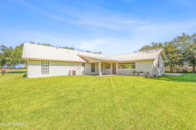 319 Roger Rd, Lafayette, LA 70507 - rear view of property with brick siding, a metal roof, a lawn, and a patio area