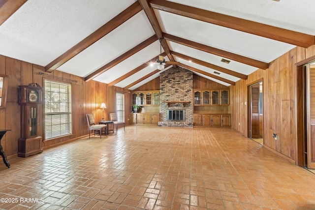 319 Roger Rd, Lafayette, LA 70507 - unfurnished living room featuring wood walls, ceiling fan, brick flooring, and a brick fireplace