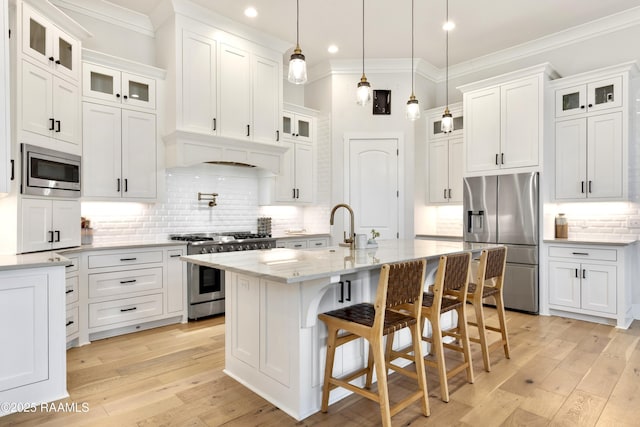 kitchen with crown molding, appliances with stainless steel finishes, tasteful backsplash, and white cabinets