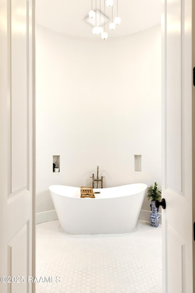 full bath with baseboards, tile patterned flooring, and a soaking tub
