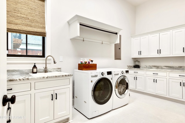 clothes washing area with washing machine and clothes dryer, a sink, electric panel, and cabinet space