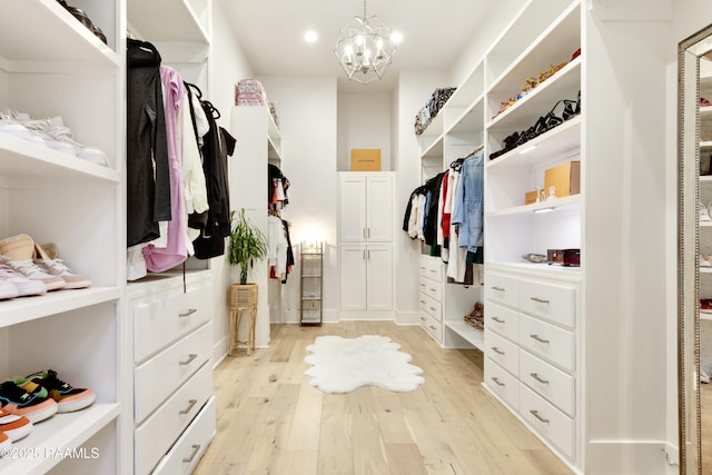 spacious closet featuring an inviting chandelier and light wood-style flooring