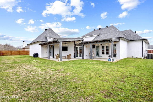 rear view of property with ceiling fan, a fenced backyard, french doors, a patio area, and a yard