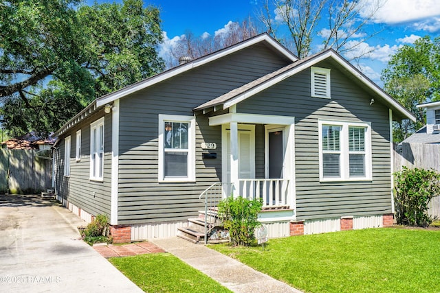 bungalow with a front yard and fence