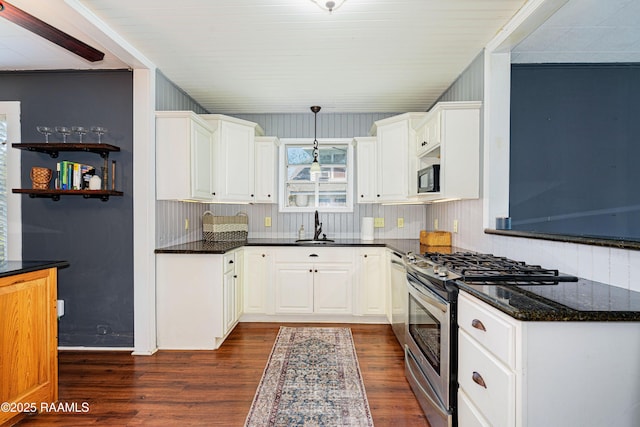 kitchen with a sink, white cabinets, gas range, dark wood-type flooring, and black microwave