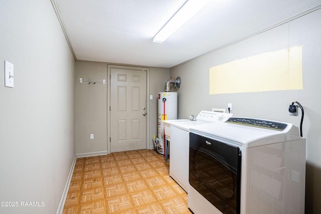 laundry area featuring baseboards, laundry area, washer and dryer, and gas water heater
