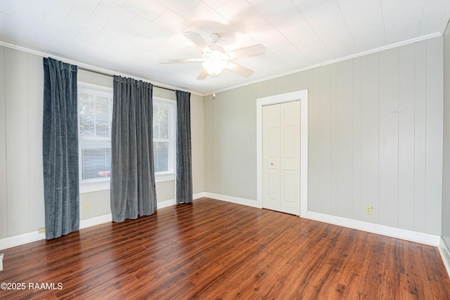 spare room with ornamental molding, baseboards, a ceiling fan, and wood finished floors