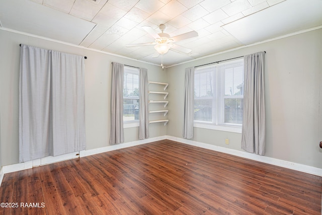 empty room with ornamental molding, baseboards, a ceiling fan, and wood finished floors