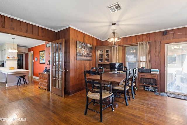 202 Sapphire Dr, Lafayette, LA 70506 - dining area with visible vents, wooden walls, ornamental molding, and a notable chandelier