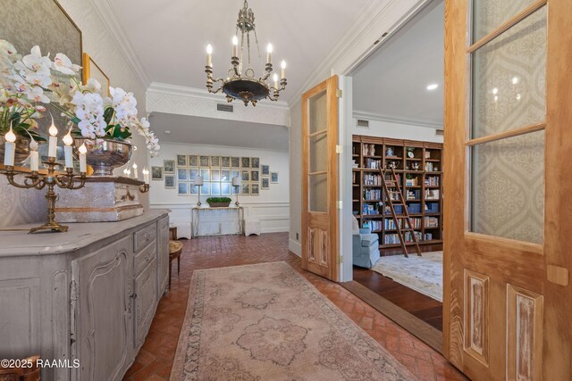 interior space featuring crown molding, a notable chandelier, and visible vents