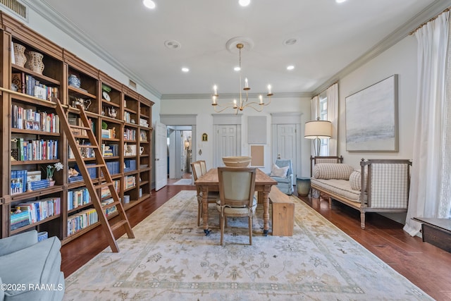 dining room featuring ornamental molding, an inviting chandelier, visible vents, and wood finished floors