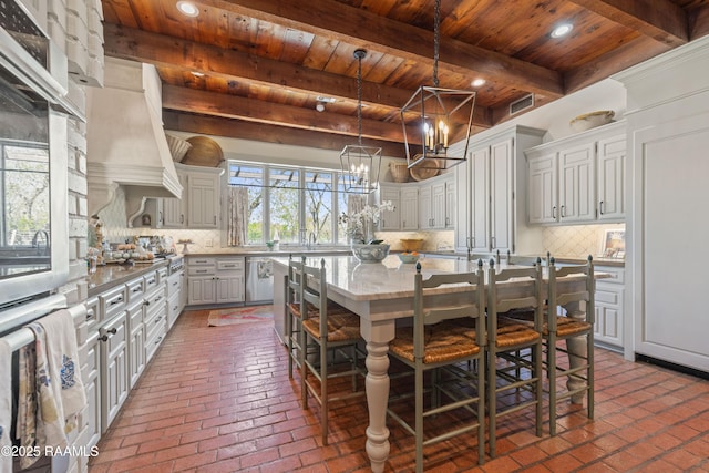 kitchen with wooden ceiling, brick floor, decorative backsplash, and a kitchen island