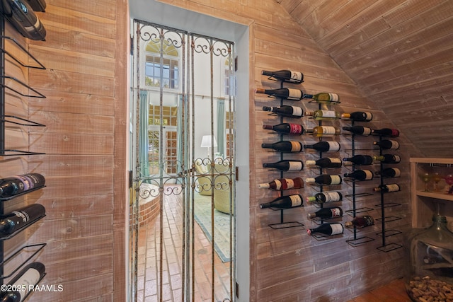 wine room with wood walls, wooden ceiling, and vaulted ceiling