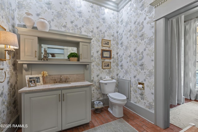bathroom featuring vanity, toilet, brick floor, and wallpapered walls