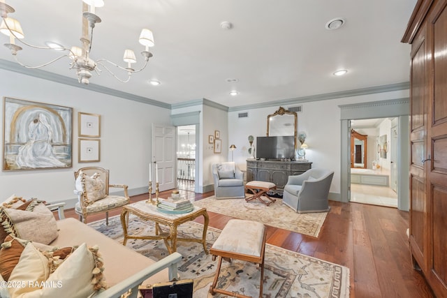 living room featuring wood-type flooring, a chandelier, visible vents, and ornamental molding